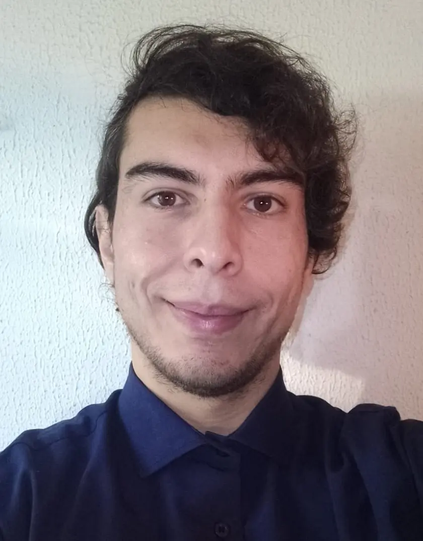 Headshot image of Facundo Escobar, founder of FELS. He's wearing a blue shirt, he's smiling and he has a mildly messy curly haircut combed to his left side.